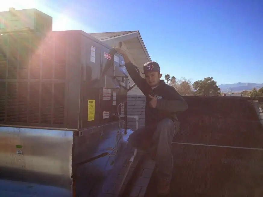 HVAC technician performing Heat Pump Repair on a rooftop unit in McGregor